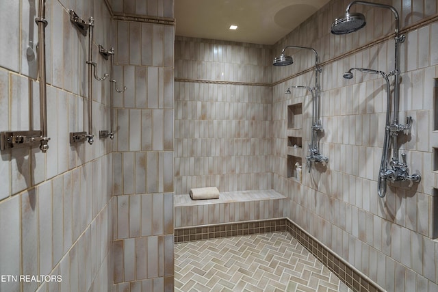 bathroom with brick floor and tiled shower