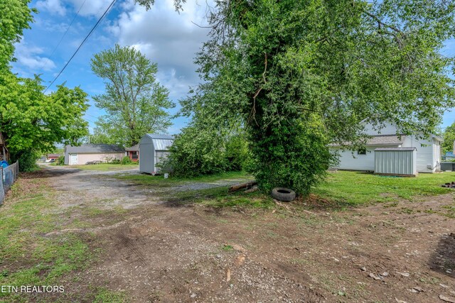 view of yard featuring a storage shed and an outbuilding