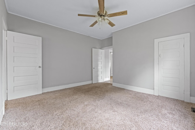 unfurnished bedroom featuring visible vents, carpet floors, and crown molding