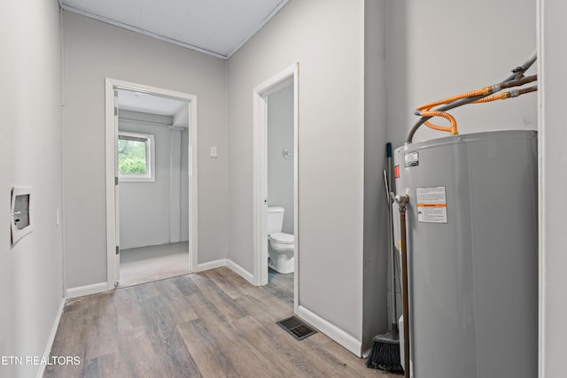 utility room with visible vents and electric water heater