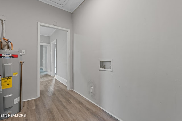 washroom with washer hookup, laundry area, water heater, ornamental molding, and wood finished floors