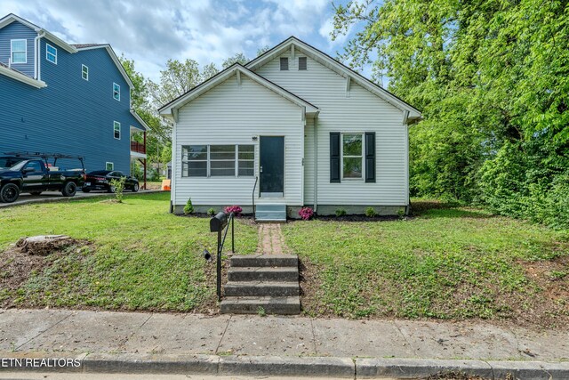 bungalow-style house featuring a front lawn and entry steps