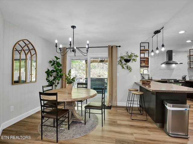 dining space featuring baseboards, recessed lighting, a notable chandelier, and light wood finished floors