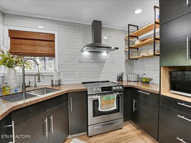 kitchen featuring decorative backsplash, a sink, electric stove, light stone countertops, and wall chimney exhaust hood