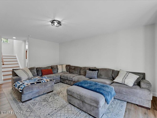 living area with stairway and wood finished floors