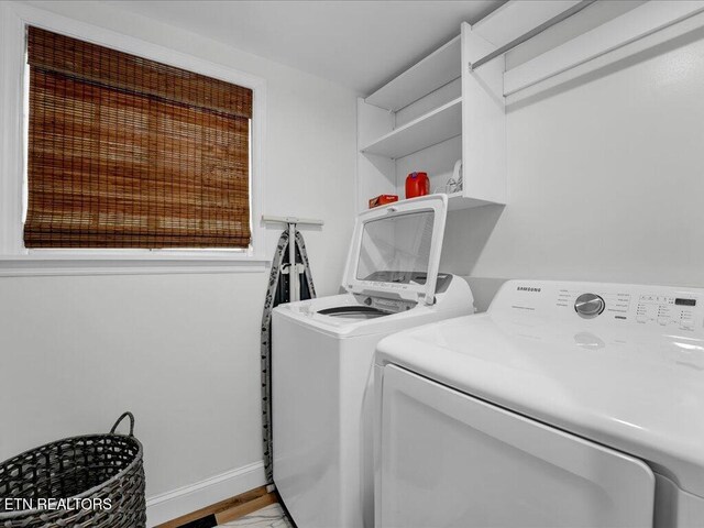 washroom featuring baseboards, washing machine and clothes dryer, laundry area, and light wood-style flooring
