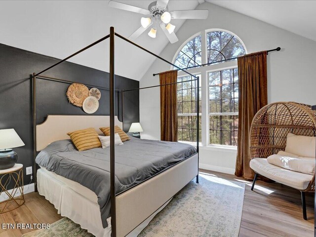 bedroom featuring wood finished floors, ceiling fan, high vaulted ceiling, and baseboards