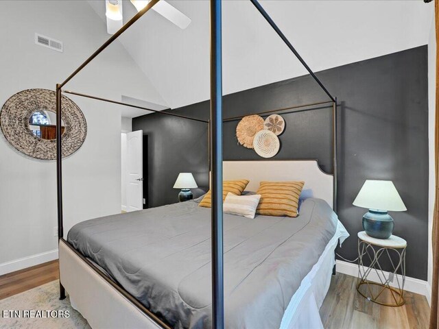bedroom featuring baseboards, visible vents, and wood finished floors