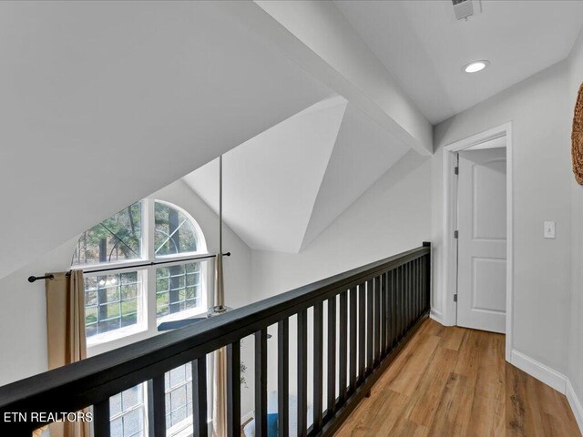 hallway featuring recessed lighting, wood finished floors, visible vents, baseboards, and lofted ceiling