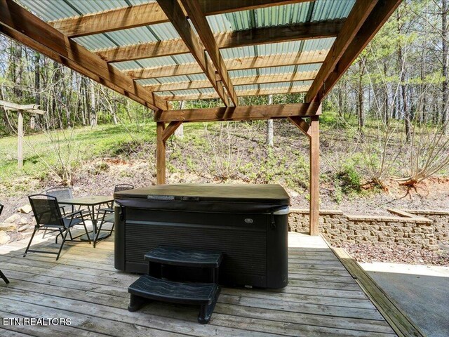 deck with outdoor dining space and a hot tub