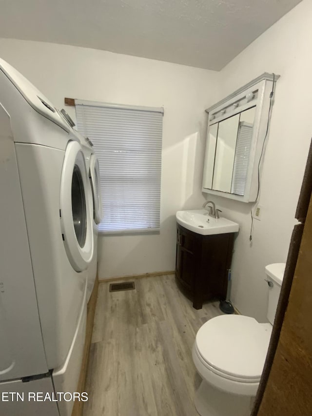 2789 Oak Grove Rd, Rocky Top, TN 37769 - bathroom featuring vanity, washer / dryer, toilet, visible vents, and wood finished floors
