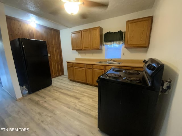 2789 Oak Grove Rd, Rocky Top, TN 37769 - kitchen with light wood-type flooring, black appliances, brown cabinets, and a sink