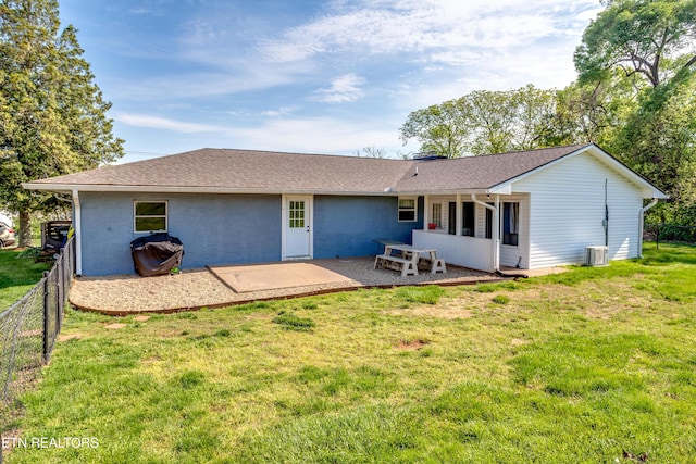 back of property featuring fence, a shingled roof, a patio, central AC, and a lawn