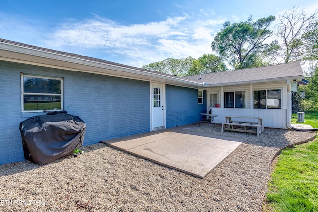 back of house featuring brick siding and a patio area