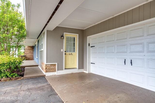 view of exterior entry with driveway and stone siding