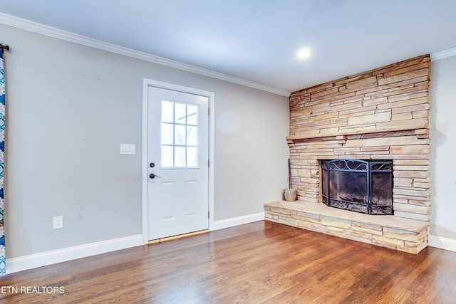 living area featuring baseboards, wood finished floors, a fireplace, and crown molding