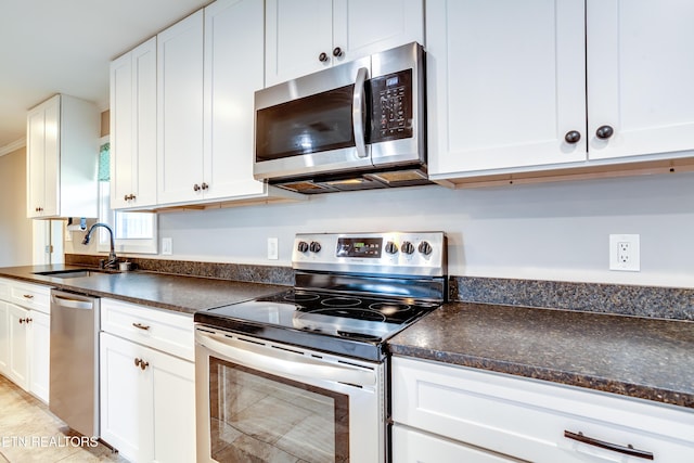 kitchen with dark countertops, appliances with stainless steel finishes, and a sink