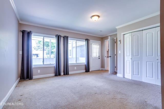 unfurnished bedroom with baseboards, ornamental molding, a closet, and carpet