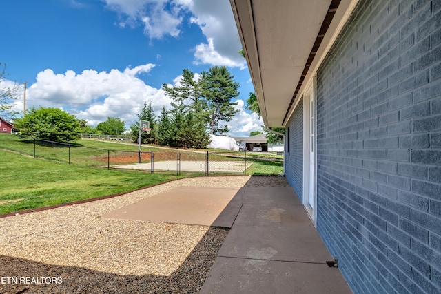 view of property exterior featuring a yard, a patio area, and fence