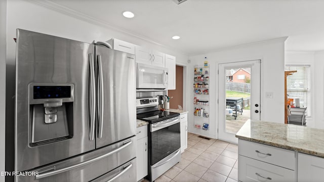 kitchen featuring crown molding, light stone counters, stainless steel appliances, white cabinetry, and light tile patterned floors