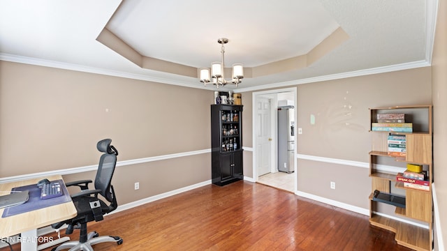 office area featuring crown molding, wood finished floors, baseboards, a chandelier, and a tray ceiling