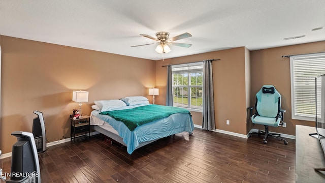 bedroom with baseboards, a ceiling fan, wood finished floors, and visible vents