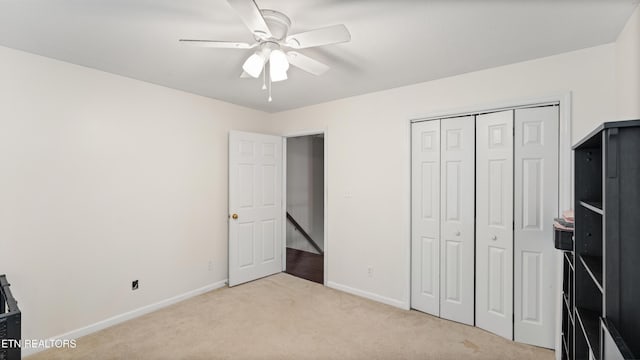 unfurnished bedroom with a closet, baseboards, carpet, and a ceiling fan