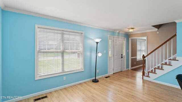 entrance foyer featuring baseboards, visible vents, wood finished floors, and stairway