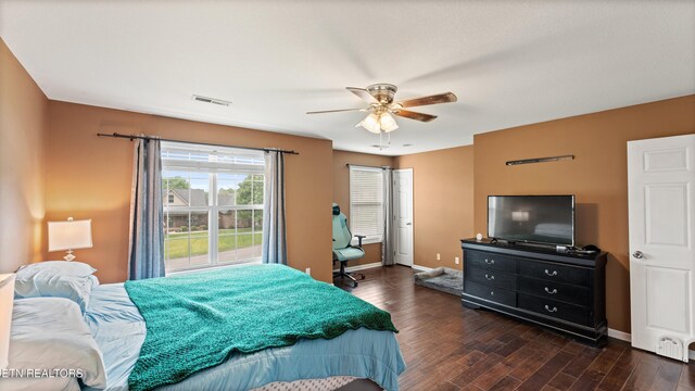 bedroom with visible vents, baseboards, ceiling fan, and dark wood-style floors