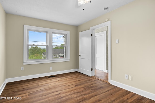 unfurnished bedroom featuring baseboards, visible vents, wood finished floors, and ceiling fan