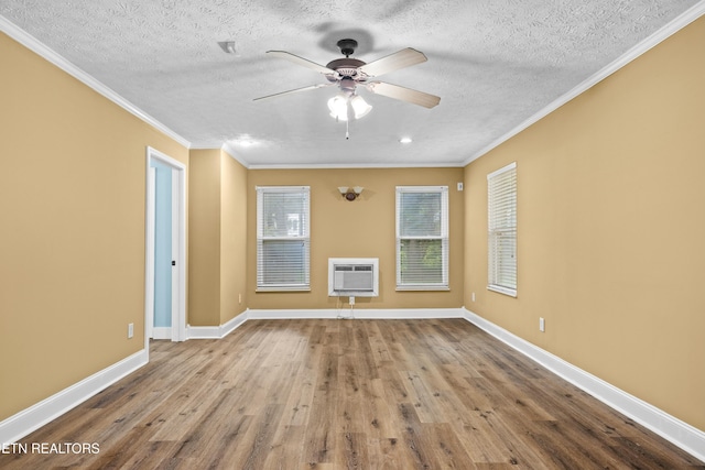 empty room with a textured ceiling, wood finished floors, a ceiling fan, and crown molding