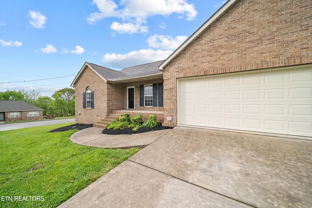 4762 Cabbage Ln, Knoxville, TN 37938 - ranch-style house featuring brick siding, a garage, roof with shingles, a front yard, and concrete driveway