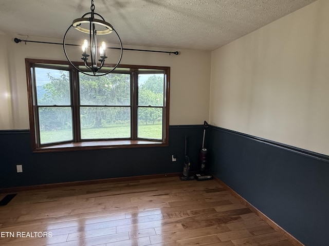 391 Underwood Grove Rd, Cumberland Gap, TN 37724 - spare room featuring a chandelier, wood finished floors, and a textured ceiling