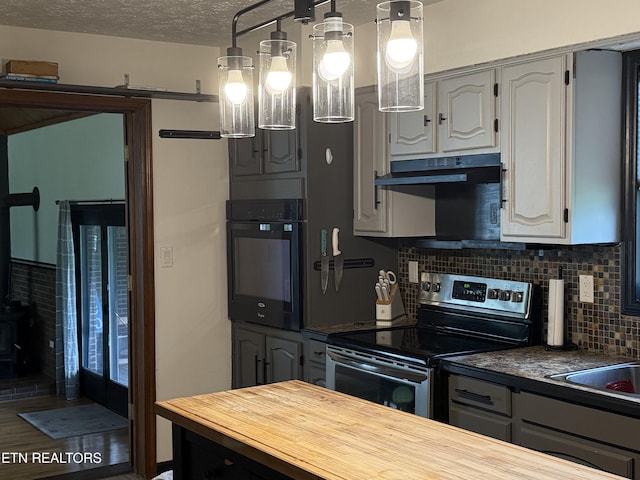391 Underwood Grove Rd, Cumberland Gap, TN 37724 - kitchen with stainless steel electric stove, black oven, butcher block countertops, tasteful backsplash, and a wood stove
