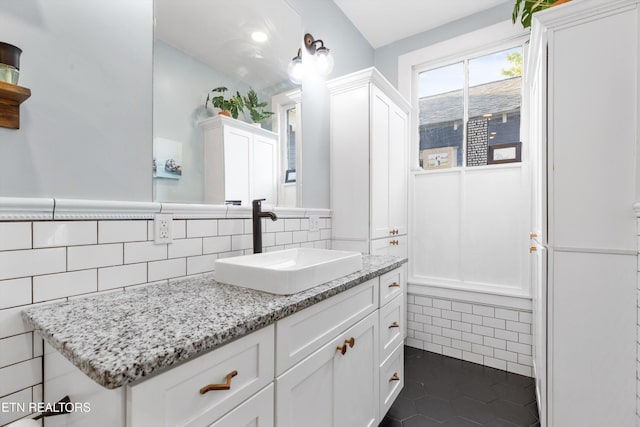 bathroom with wainscoting, tile walls, tile patterned flooring, and vanity
