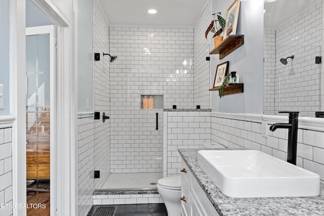 bathroom featuring vanity, toilet, recessed lighting, tile walls, and a stall shower