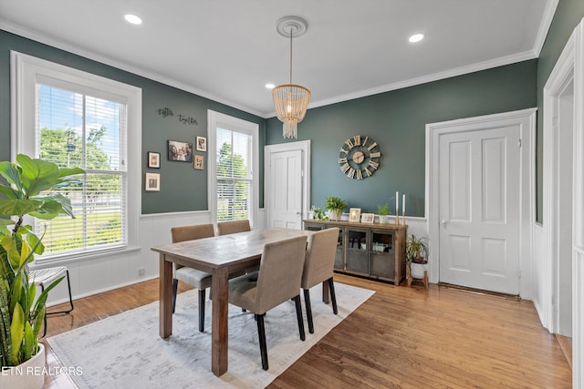 dining area with a notable chandelier, a wainscoted wall, recessed lighting, light wood-type flooring, and ornamental molding