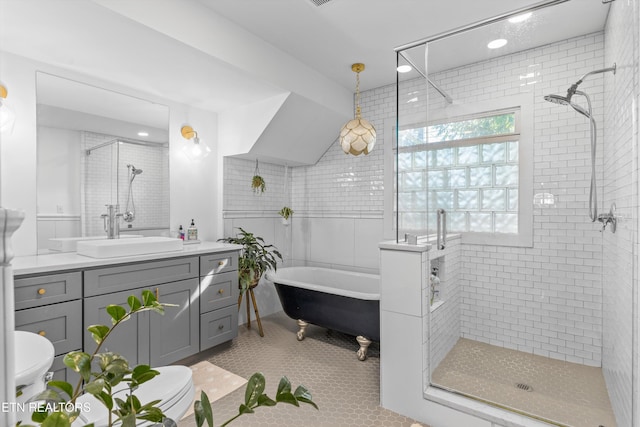 bathroom featuring vanity, a soaking tub, tile patterned flooring, and a stall shower