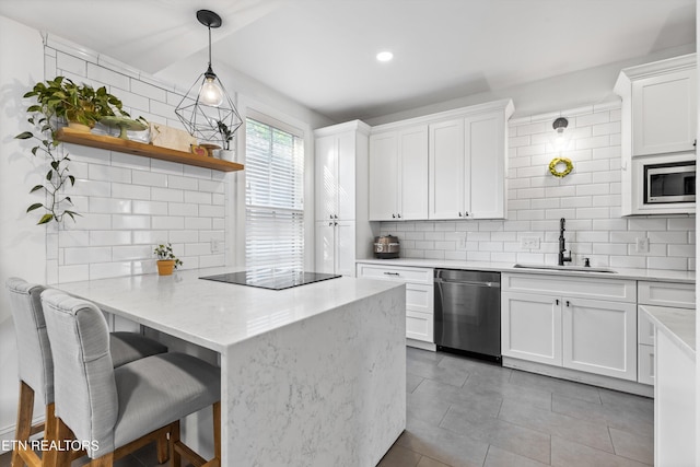 kitchen with a sink, appliances with stainless steel finishes, decorative backsplash, and a peninsula
