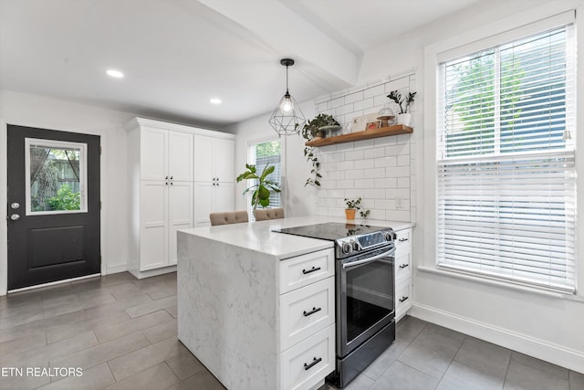 kitchen featuring white cabinets, electric range, tile patterned floors, and baseboards