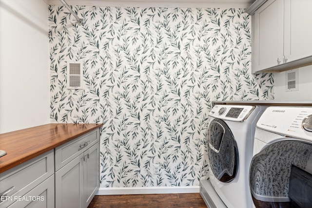 laundry area featuring cabinet space, dark wood-style floors, washer and dryer, and wallpapered walls