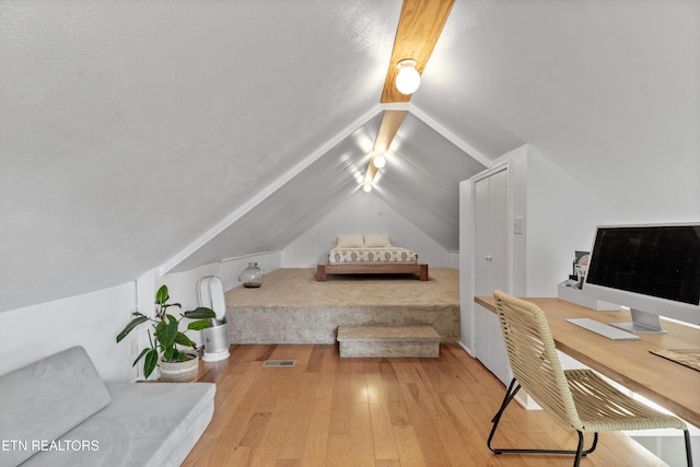 bedroom featuring visible vents, vaulted ceiling, and hardwood / wood-style flooring