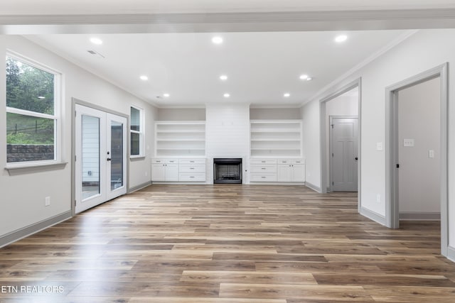 unfurnished living room with recessed lighting, wood finished floors, a large fireplace, baseboards, and crown molding