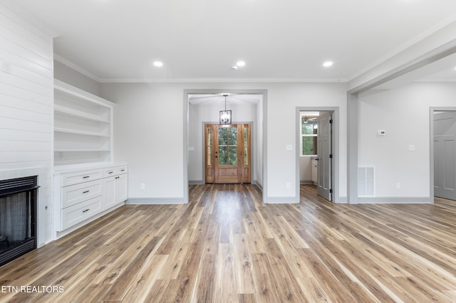 unfurnished living room with a large fireplace, light wood-style floors, visible vents, baseboards, and ornamental molding