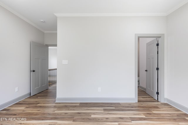 unfurnished room featuring crown molding, baseboards, and light wood-type flooring