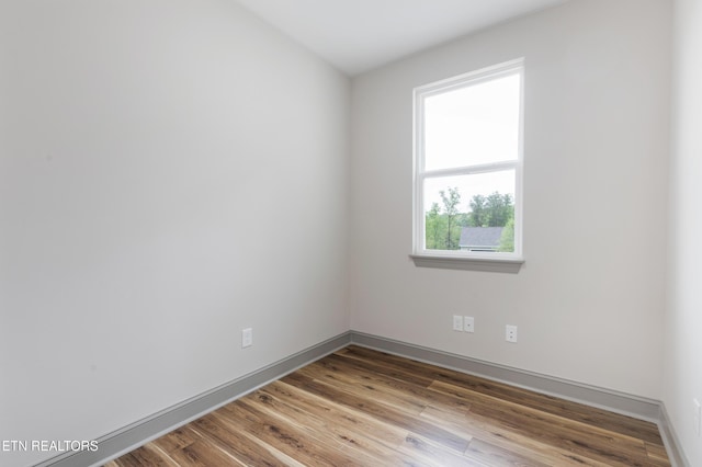 spare room featuring wood finished floors and baseboards