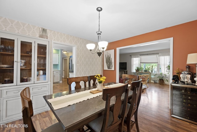 705 Kimbee Rd, Knoxville, TN 37923 - dining area featuring dark wood finished floors, wine cooler, wallpapered walls, and a notable chandelier