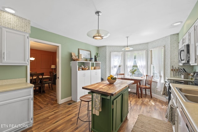 705 Kimbee Rd, Knoxville, TN 37923 - kitchen featuring pendant lighting, wood finished floors, butcher block countertops, green cabinets, and stainless steel appliances