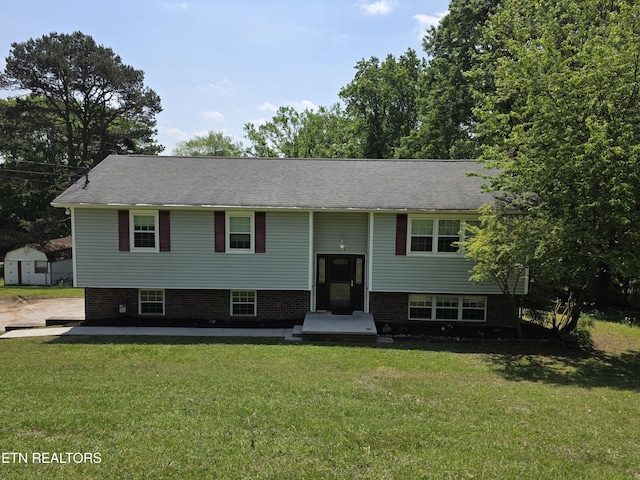 split foyer home with an outbuilding, a front lawn, and a storage shed