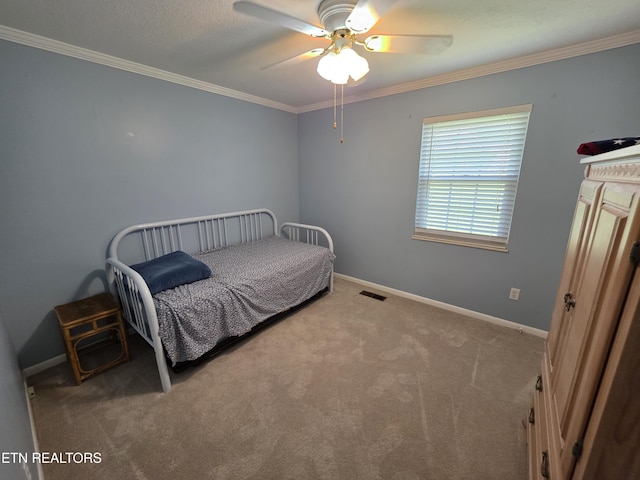 carpeted bedroom with baseboards, visible vents, ornamental molding, and ceiling fan